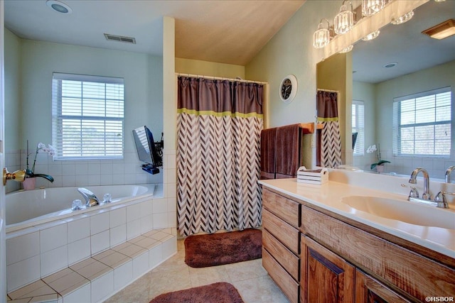 bathroom with a healthy amount of sunlight, vanity, a bath, and tile patterned floors