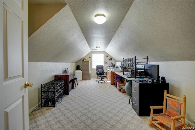 office area featuring light carpet, vaulted ceiling, a textured ceiling, and baseboards