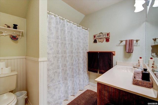 full bathroom featuring a wainscoted wall, toilet, and vanity