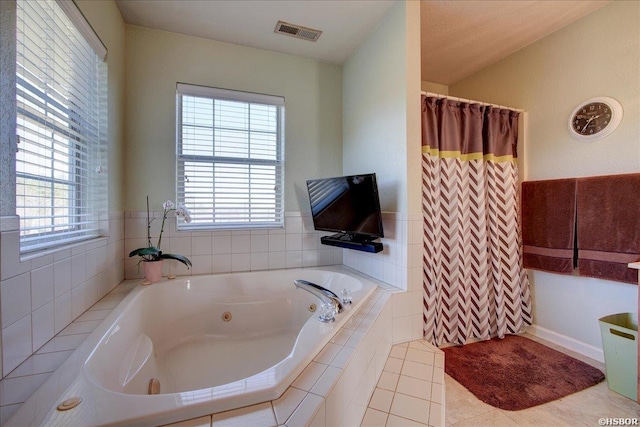 bathroom featuring a jetted tub, tile patterned floors, visible vents, and a healthy amount of sunlight