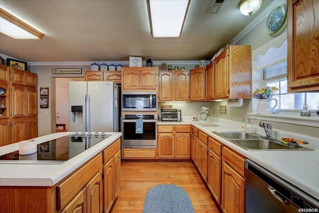 kitchen featuring a sink, stainless steel appliances, light countertops, and crown molding