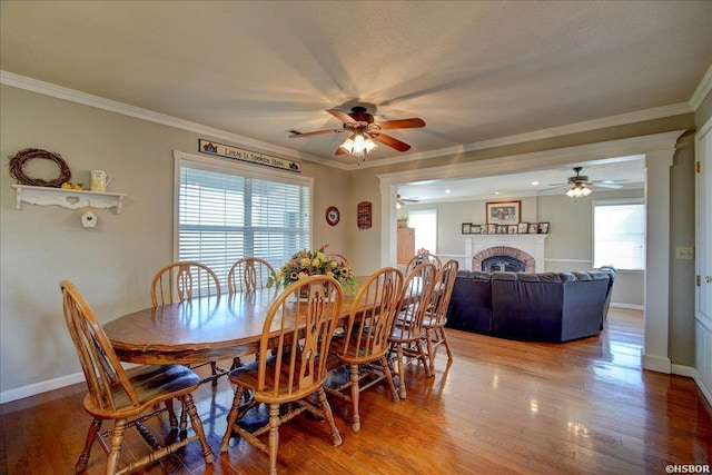 dining area with ornamental molding, a wealth of natural light, and wood finished floors