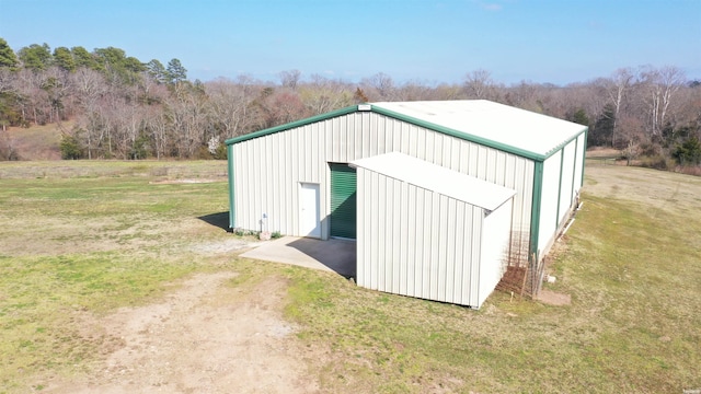 view of pole building featuring driveway and a yard