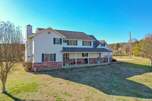 view of front of house with a front yard, brick siding, and a chimney