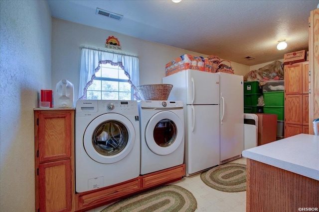 laundry room with laundry area, visible vents, independent washer and dryer, a textured ceiling, and light floors