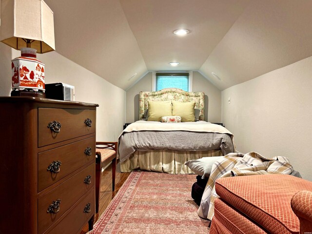 bedroom with vaulted ceiling and light wood-style floors