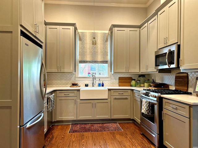 kitchen featuring ornamental molding, appliances with stainless steel finishes, gray cabinets, and dark wood finished floors