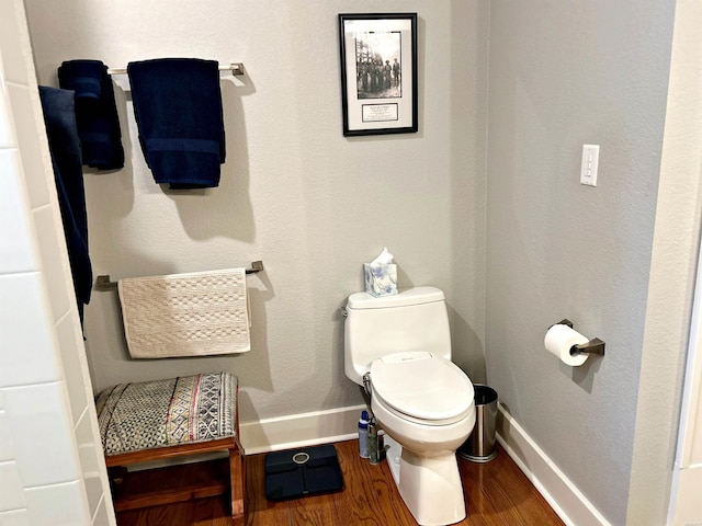 bathroom featuring baseboards, toilet, and wood finished floors