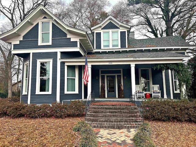 view of front of home with a porch and roof with shingles