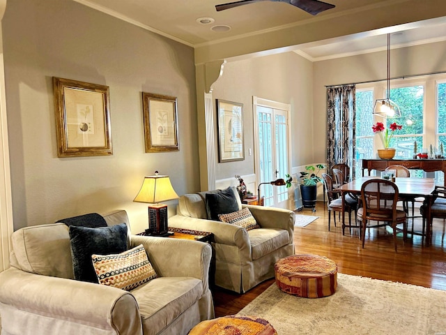 living area featuring ceiling fan, crown molding, and wood finished floors