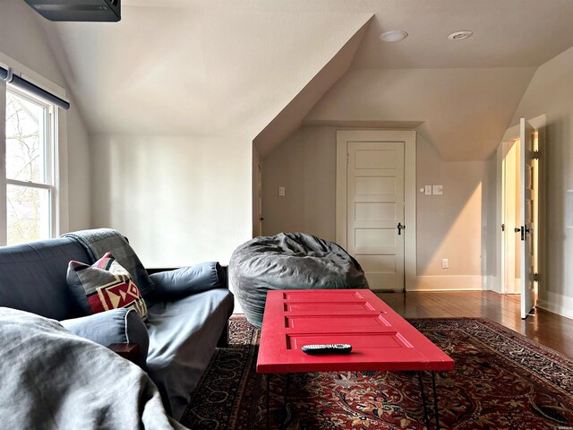 interior space with vaulted ceiling, dark wood finished floors, and baseboards