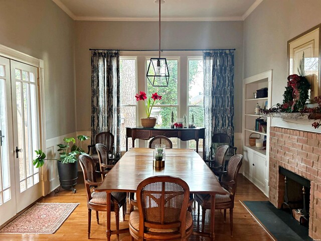 dining space with french doors, wood finished floors, and crown molding