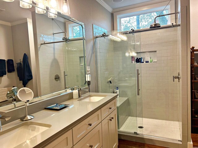 full bath featuring double vanity, a stall shower, crown molding, and a sink