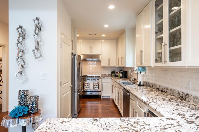 1129 Marion Anderson Rd, Hot Springs, AR 71913 - kitchen featuring appliances with stainless steel finishes, a sink, under cabinet range hood, light stone counters, and white cabinetry
