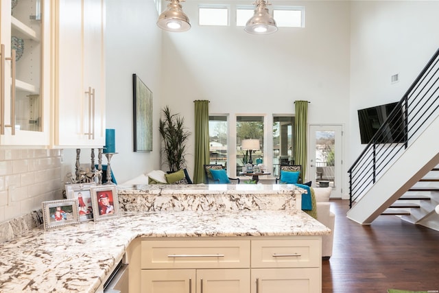1129 Marion Anderson Rd, Hot Springs, AR 71913 - kitchen with a towering ceiling, a peninsula, open floor plan, light stone countertops, and dark wood-type flooring