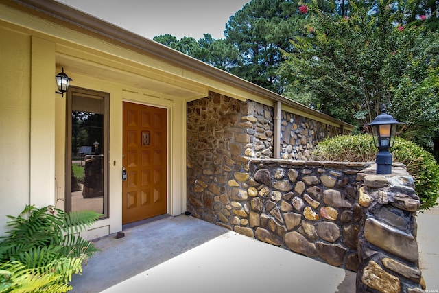 property entrance with stone siding