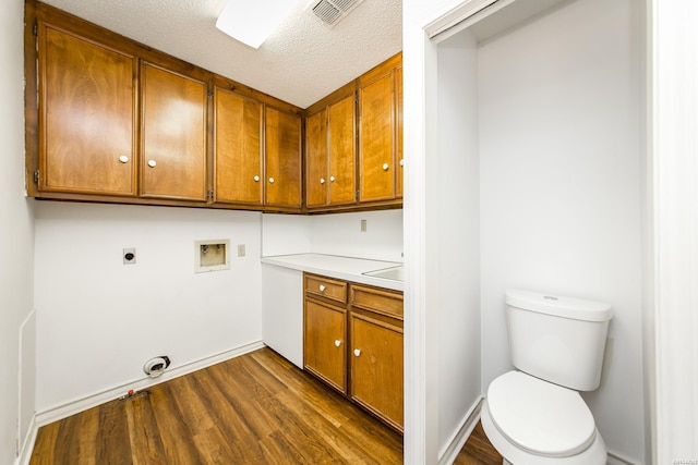 washroom with hookup for a washing machine, visible vents, hookup for an electric dryer, cabinet space, and dark wood-type flooring