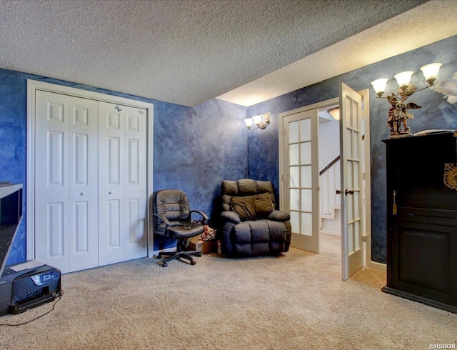 living area with a textured ceiling, french doors, and carpet floors