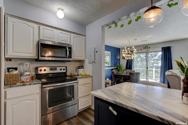 kitchen featuring a notable chandelier, a textured ceiling, dark wood-style flooring, backsplash, and stainless steel appliances