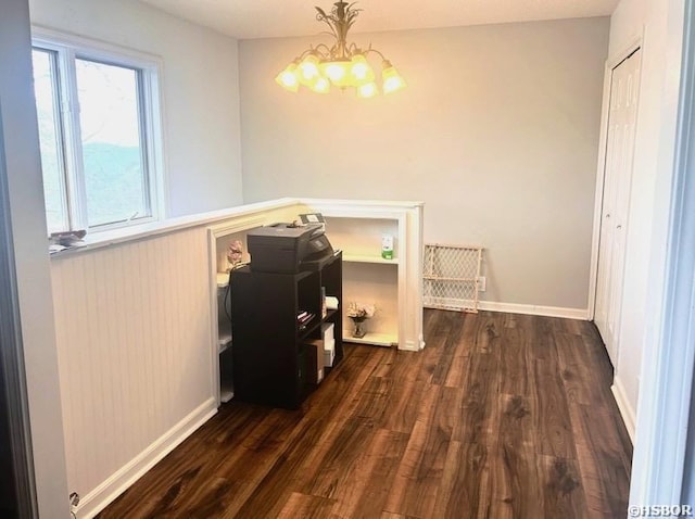dining space with baseboards, dark wood finished floors, and a chandelier