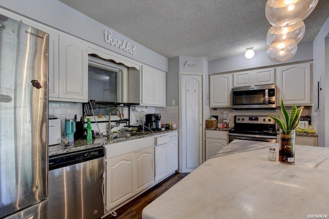 kitchen featuring white cabinetry, appliances with stainless steel finishes, and decorative backsplash