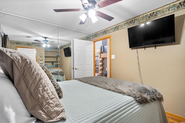 bedroom with a textured ceiling, visible vents, and a ceiling fan