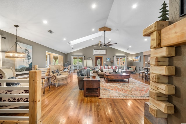 living room featuring recessed lighting, visible vents, lofted ceiling with skylight, a ceiling fan, and wood finished floors