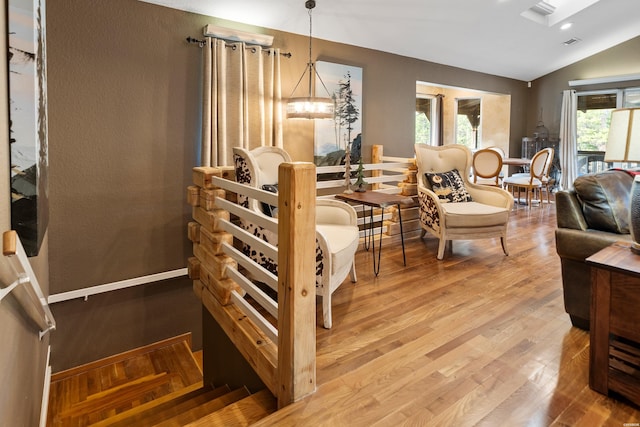 interior space with vaulted ceiling, wood finished floors, visible vents, and baseboards