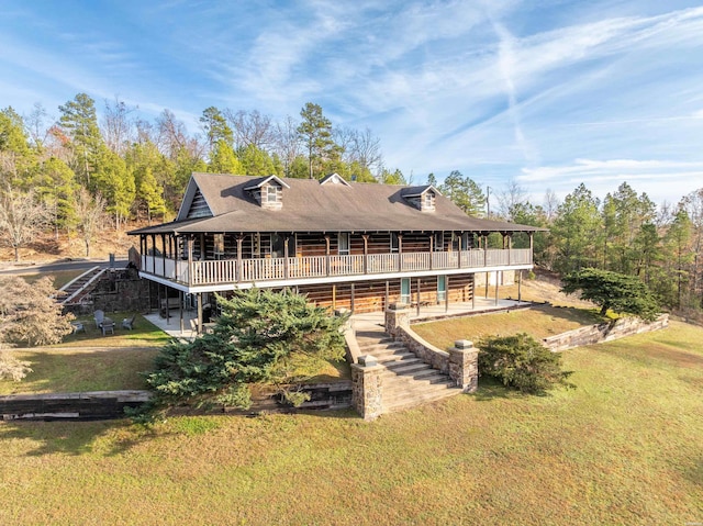 view of front of home with a deck, a patio, and a front yard