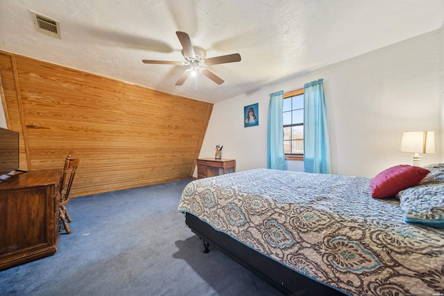 bedroom featuring carpet, visible vents, a ceiling fan, vaulted ceiling, and a textured ceiling