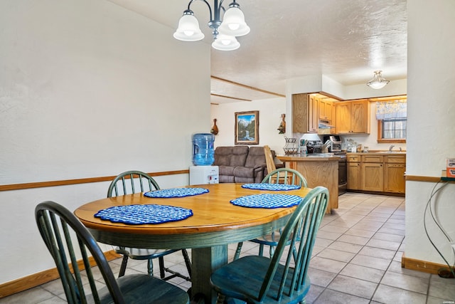 dining area with an inviting chandelier, a textured ceiling, baseboards, and light tile patterned floors