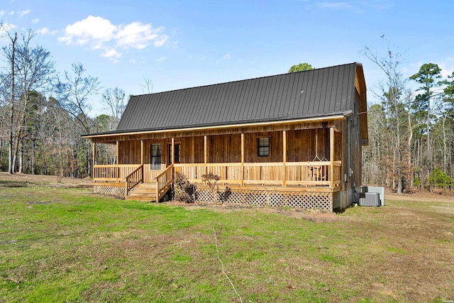 view of front of property with a porch, cooling unit, metal roof, and a front lawn