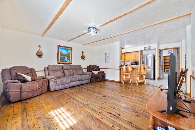 living room with light wood-style floors, baseboards, and a textured ceiling