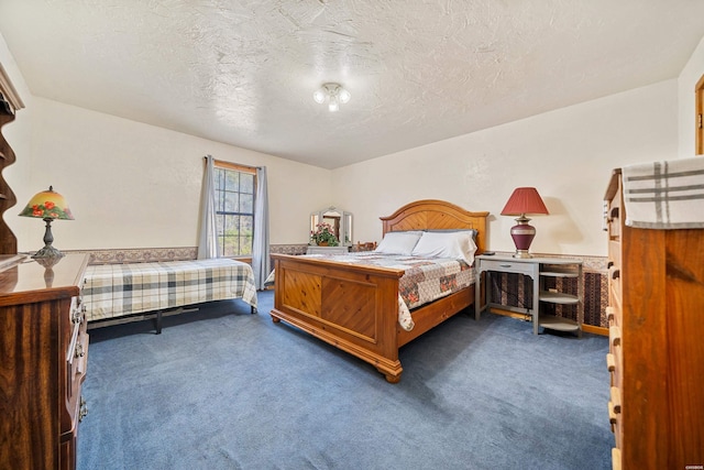 bedroom featuring dark carpet and a textured ceiling