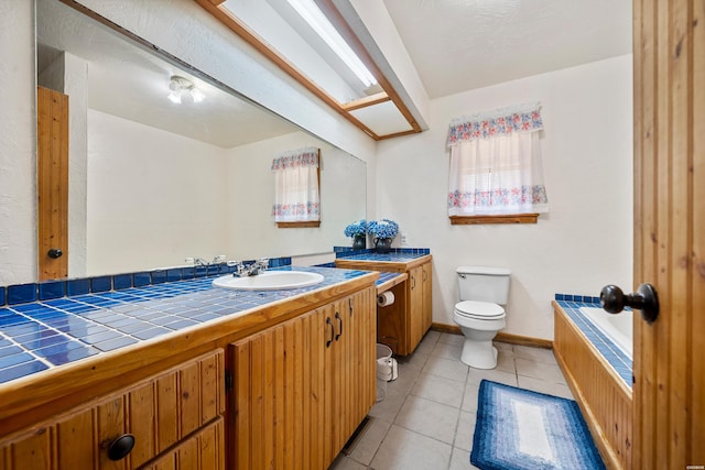 bathroom with baseboards, vanity, toilet, and tile patterned floors