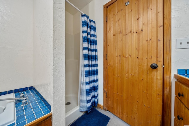 bathroom featuring a sink and a shower stall