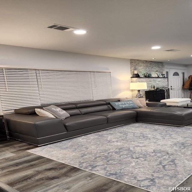 living room with wood finished floors, visible vents, and recessed lighting