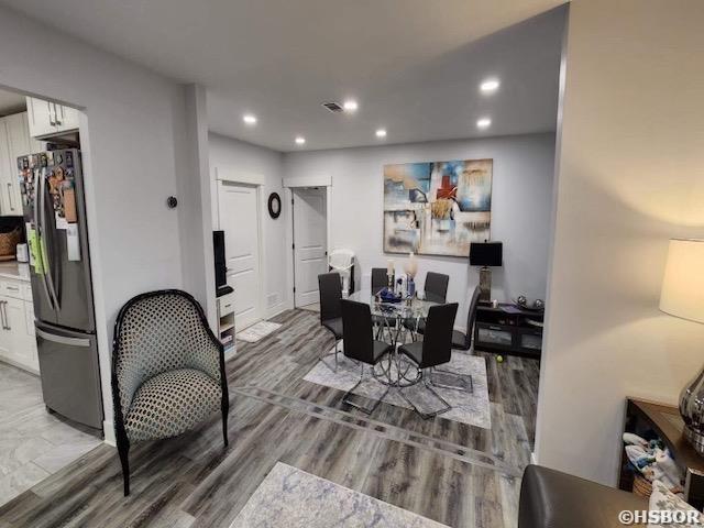 dining area with wood finished floors and recessed lighting