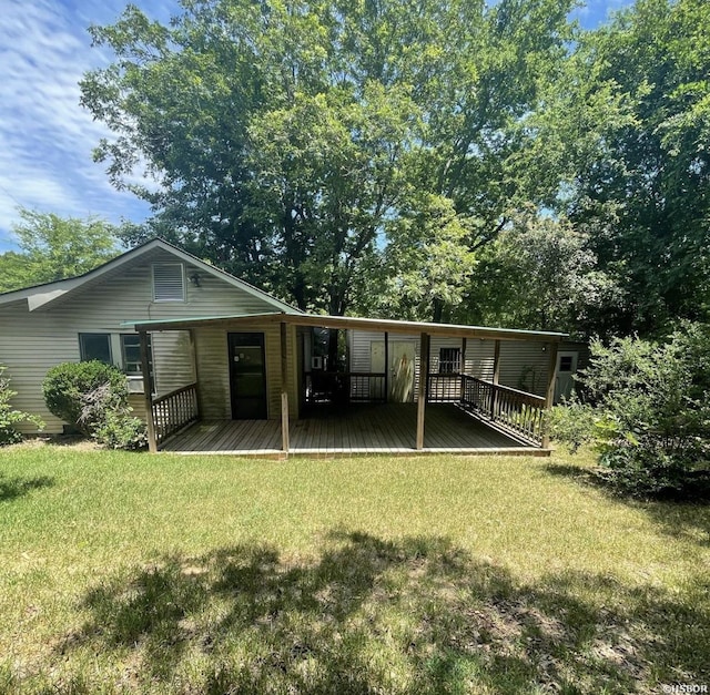 rear view of house featuring a lawn and a wooden deck