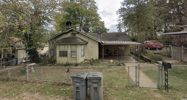 bungalow-style home with a fenced front yard, a gate, and stucco siding