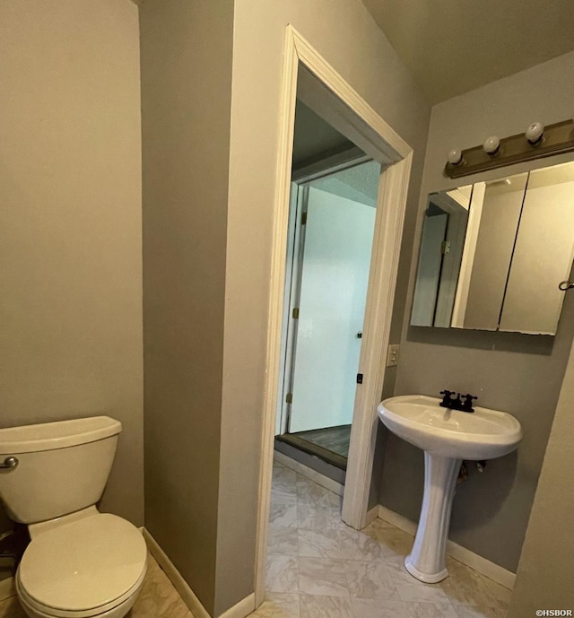 bathroom featuring toilet and baseboards