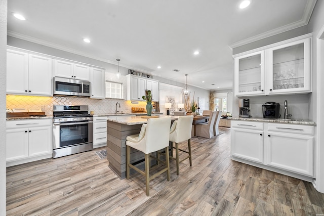 125 Eagle View Pt, Hot Springs, AR 71913 - kitchen featuring stainless steel appliances, white cabinetry, a center island, tasteful backsplash, and crown molding