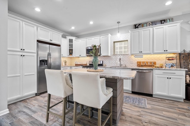 125 Eagle View Pt, Hot Springs, AR 71913 - kitchen with stainless steel appliances, ornamental molding, white cabinetry, a breakfast bar area, and backsplash