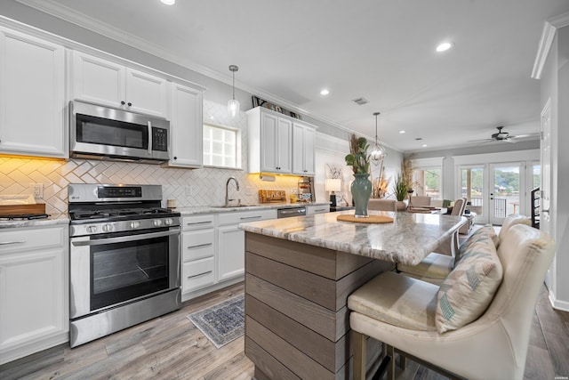 125 Eagle View Pt, Hot Springs, AR 71913 - kitchen featuring stainless steel appliances, a sink, a breakfast bar area, recessed lighting, and white cabinets