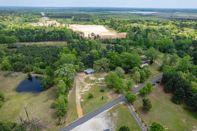 birds eye view of property with a view of trees and a water view