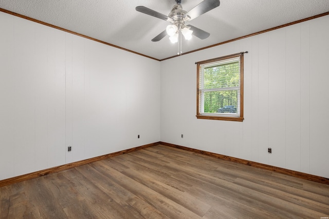 unfurnished room featuring a ceiling fan, wood finished floors, a textured ceiling, and ornamental molding