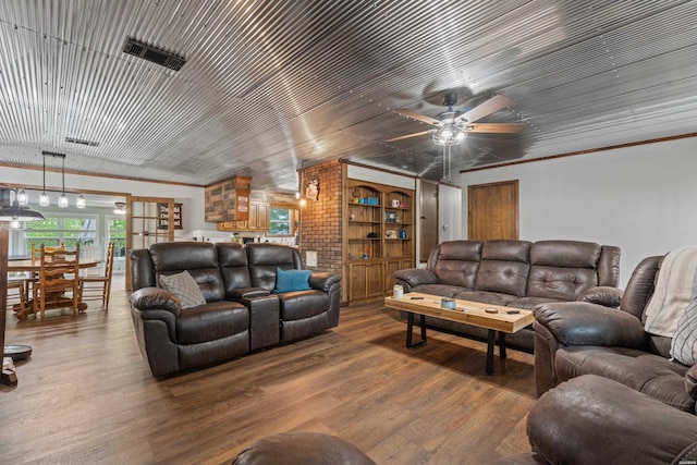 living area with a ceiling fan, wood finished floors, and visible vents