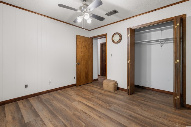 unfurnished bedroom with baseboards, wood finished floors, visible vents, and crown molding
