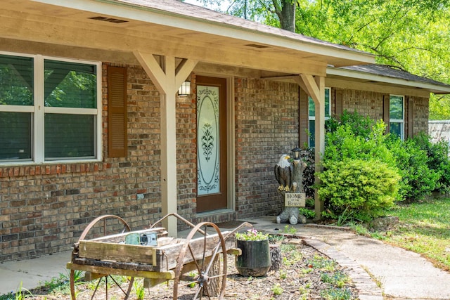 doorway to property with brick siding
