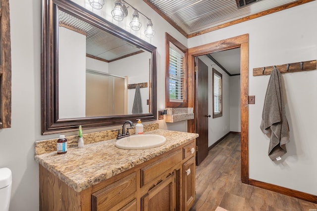 bathroom with baseboards, crown molding, vanity, and wood finished floors